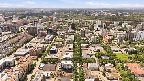 Aerial perspective showcasing a vibrant urban landscape with diverse architectural styles, including multi-story residential buildings and commercial structures - #433 11217 103 Av Nw, Edmonton, AB - Outdoor With View