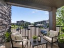 Private balcony featuring a black metal railing and a stone-clad exterior wall - #217 12045 22 Av Sw, Edmonton, AB  - Outdoor With Deck Patio Veranda With Exterior 