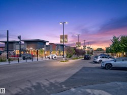 Retail frontage featuring modern architectural design with stone accents, storefront windows, and exterior lighting - 