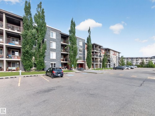 Multi-story residential building featuring stone and siding exterior accents - #217 12045 22 Av Sw, Edmonton, AB - Outdoor With Balcony With Facade