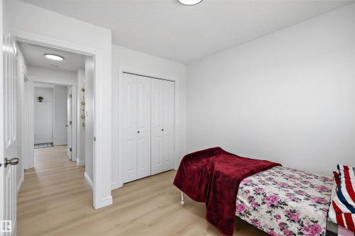 Bright room featuring wood-finish flooring, white walls, and a built-in closet with bi-fold doors - 2803 12 Street Nw, Edmonton, AB - Indoor Photo Showing Bedroom