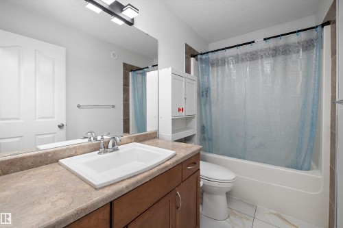 Vanity with a built-in sink, chrome faucet, and substantial countertop space - 2803 12 Street Nw, Edmonton, AB - Indoor Photo Showing Bathroom
