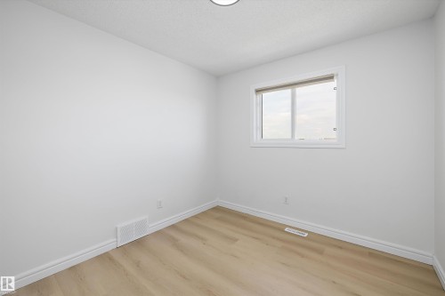 Bright room featuring light wood-finish flooring, white baseboards, and a white framed window - 2803 12 Street Nw, Edmonton, AB - Indoor Photo Showing Other Room
