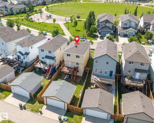 Rear elevation featuring a two-story design, attached elevated deck with stairs, a detached single-car garage, and a fenced backyard - 2803 12 Street Nw, Edmonton, AB - Outdoor With View