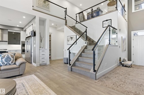 Living area with light wood-type flooring, a towering ceiling, stairway, and recessed lighting - 3167 Cameron Heights Way Nw, Edmonton, AB - Indoor Photo Showing Other Room
