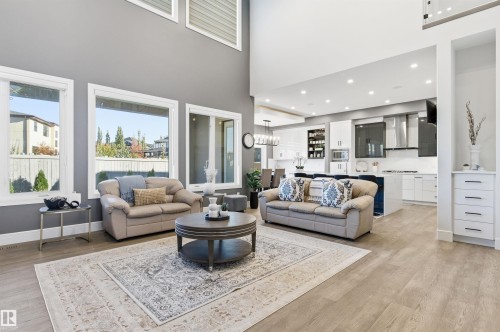 Living room featuring a chandelier, light wood-style floors, a high ceiling, and recessed lighting - 3167 Cameron Heights Way Nw, Edmonton, AB - Indoor Photo Showing Living Room