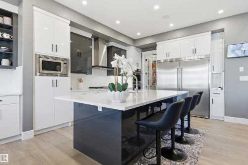 Kitchen with white cabinets, modern cabinets, a breakfast bar, built in appliances, and recessed lighting - 3167 Cameron Heights Way Nw, Edmonton, AB - Indoor Photo Showing Kitchen With Upgraded Kitchen