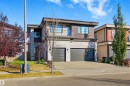 Contemporary house with stone siding, a balcony, concrete driveway, and a garage - 3167 Cameron Heights Way Nw, Edmonton, AB  - Outdoor With Balcony 