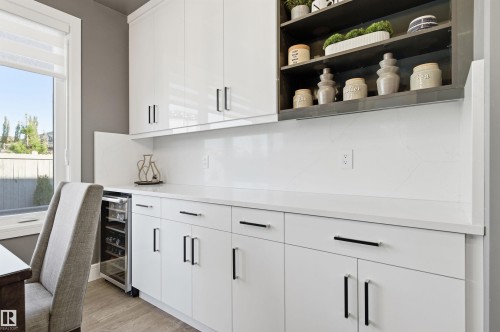 Indoor dry bar with open shelves, white cabinetry, light wood-type flooring, beverage cooler, and light stone countertops - 3167 Cameron Heights Way Nw, Edmonton, AB - Indoor Photo Showing Office