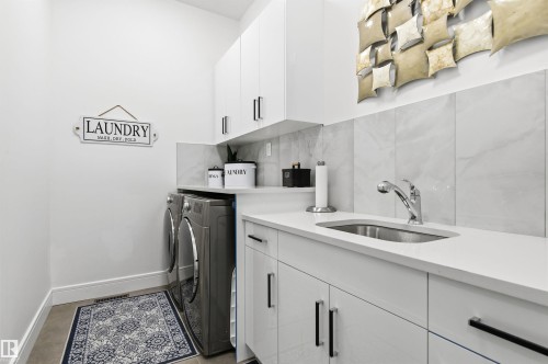 Laundry area featuring cabinet space and washer and dryer - 3167 Cameron Heights Way Nw, Edmonton, AB - Indoor Photo Showing Laundry Room