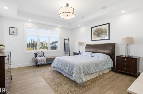 Bedroom with light wood-style flooring, a raised ceiling, and recessed lighting - 3167 Cameron Heights Way Nw, Edmonton, AB - Indoor Photo Showing Bedroom