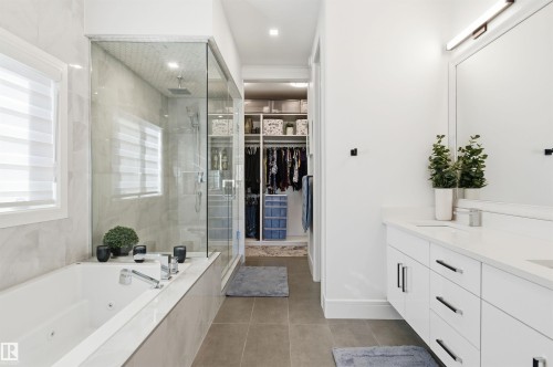 Bathroom with double vanity, a spacious closet, a shower stall, a tub with jets, and light tile patterned floors - 3167 Cameron Heights Way Nw, Edmonton, AB - Indoor Photo Showing Bathroom