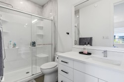 Bathroom featuring vanity and a marble finish shower - 