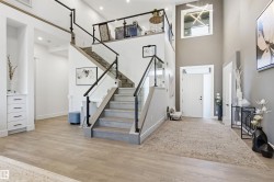Entryway featuring light wood-type flooring, stairway, and a towering ceiling - 