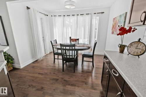 This dining area features hardwood floors and a contemporary ceiling light fixture - 1115 61 Street Sw, Edmonton, AB - Indoor Photo Showing Dining Room