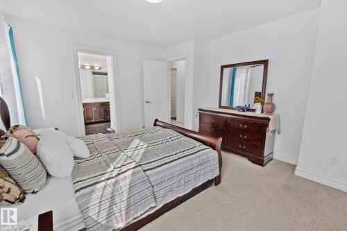 The bedroom features a light-toned carpet and white walls, creating a bright and airy atmosphere - 1115 61 Street Sw, Edmonton, AB - Indoor Photo Showing Bedroom