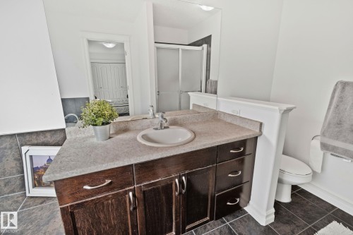 This bathroom features a vanity with a sink, a toilet, and a shower with a clear glass door - 1115 61 Street Sw, Edmonton, AB - Indoor Photo Showing Bathroom