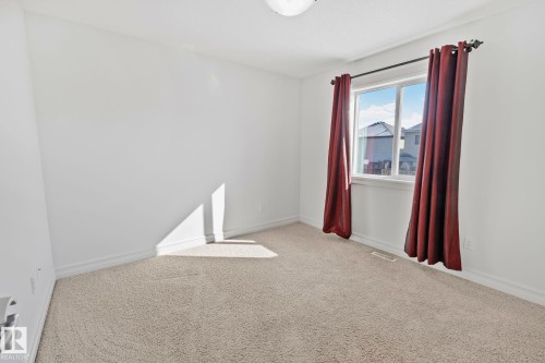 This room features light-colored carpeting, white walls, and a window providing natural light - 1115 61 Street Sw, Edmonton, AB - Indoor