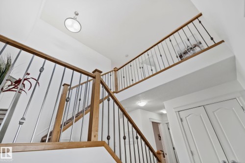 The property features a staircase with wooden handrails and metal balusters - 1115 61 Street Sw, Edmonton, AB - Indoor Photo Showing Other Room