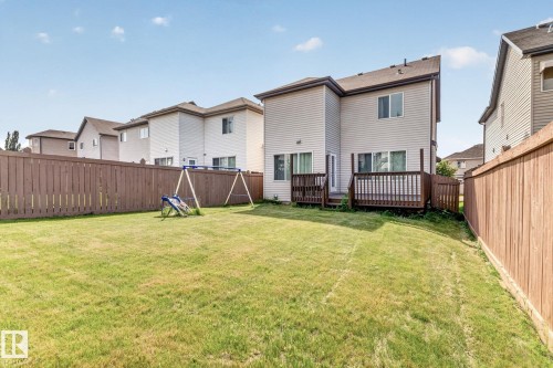 Expansive backyard featuring a manicured lawn, full privacy fencing, and a wooden deck - 1115 61 Street Sw, Edmonton, AB - Outdoor