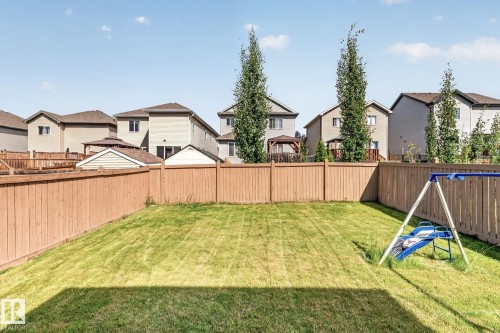 Expansive backyard featuring a manicured lawn, full wood fencing, and mature trees - 1115 61 Street Sw, Edmonton, AB - Outdoor