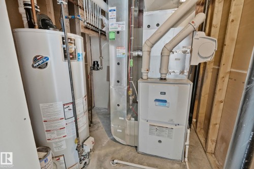 The property includes a water heater and a furnace, both visible in the utility area - 1115 61 Street Sw, Edmonton, AB - Indoor Photo Showing Basement