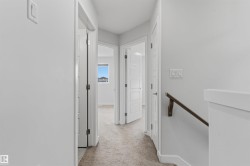 Hallway featuring light gray carpeting and white walls - 