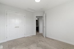 Carpeted interior room with white walls and a ceiling-mounted light fixture - 
