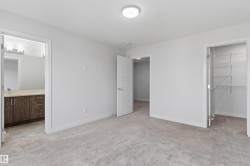 Carpeted interior room featuring light gray walls, a flush-mount ceiling light, white trim, and white paneled doors - 