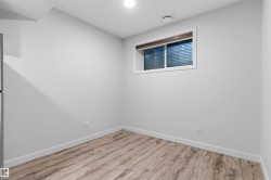 Room featuring light gray walls, wood-finish flooring, and white baseboards - 
