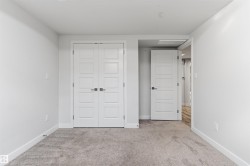 Neutral-toned room featuring a gray carpet, white walls, and bright white trim - 