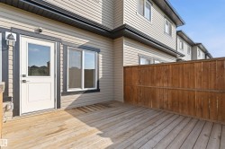 Spacious rear deck featuring natural wood flooring and privacy fencing - 