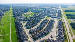 Expansive residential development featuring numerous individual properties, paved roadways, and integrated green spaces - 