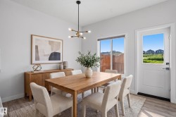 Dining area featuring wood-finish flooring and a contemporary linear chandelier - 
