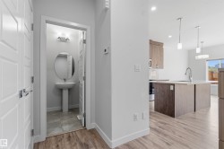 Pedestal sink with an oval mirror and wall-mounted vanity lighting - 