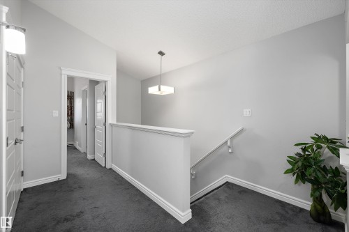 Carpeted hallway and landing with white trim - 1563 Tamarack Boulevard Nw, Edmonton, AB - Indoor Photo Showing Other Room
