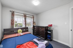 Bedroom featuring a textured ceiling, a window with horizontal muntins, and wall-to-wall carpeting - 