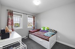 Light-filled interior space with two windows featuring white frames and grid patterns - 