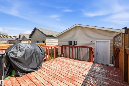 Wood deck with a red-stained finish and matching wood railings - 1563 Tamarack Boulevard Nw, Edmonton, AB - Outdoor With Deck Patio Veranda With Exterior