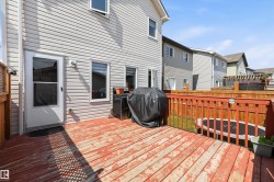 Rear wood deck with red-stained railing and light gray siding - 