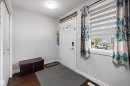 Entryway featuring a white paneled door with decorative glass inserts, wood-finish flooring, a flush-mount ceiling light, and a white-trimmed window with layered shades - 1563 Tamarack Boulevard Nw, Edmonton, AB  - Indoor Photo Showing Other Room 