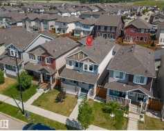 Two-story residence featuring a combination of light blue siding and decorative wood-look shingles on the gables - 