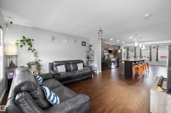 Open-concept living space featuring wood-finish flooring - 