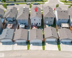 Two-story residential property featuring a gable roof, light gray siding, and multiple windows - 