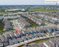 Aerial perspective of a residential neighborhood featuring detached single-family homes with gray siding and pitched roofs - 