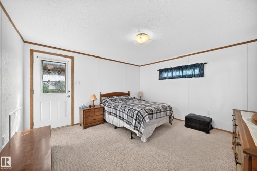 Carpeted room with white paneling and wood-finish trim - #225 3400 48 St, Stony Plain, AB - Indoor Photo Showing Bedroom