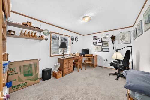 Carpeted room featuring white walls with wood trim, a window with blinds, and built-in shelving - #225 3400 48 St, Stony Plain, AB - Indoor Photo Showing Other Room