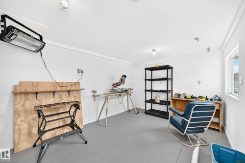 Spacious room featuring light gray flooring, white walls, and a large window providing ambient light - #225 3400 48 St, Stony Plain, AB - 