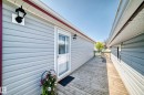 Exterior deck with wood-finish flooring, light grey horizontal siding, and a white screen door - #225 3400 48 St, Stony Plain, AB  - Outdoor With Exterior 