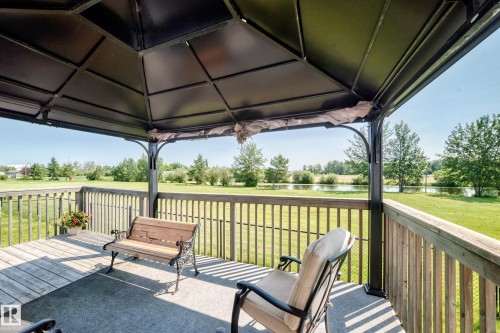 Outdoor gazebo with a black metal frame, a solid roof, and a wood-finish deck - #225 3400 48 St, Stony Plain, AB - Outdoor With Deck Patio Veranda With Exterior